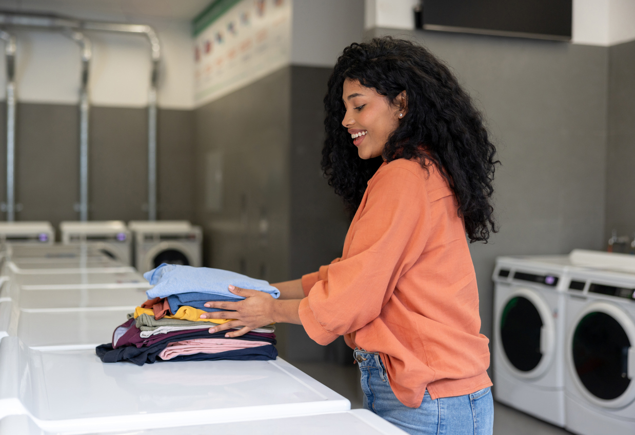 Woman folding laundry at laundromat