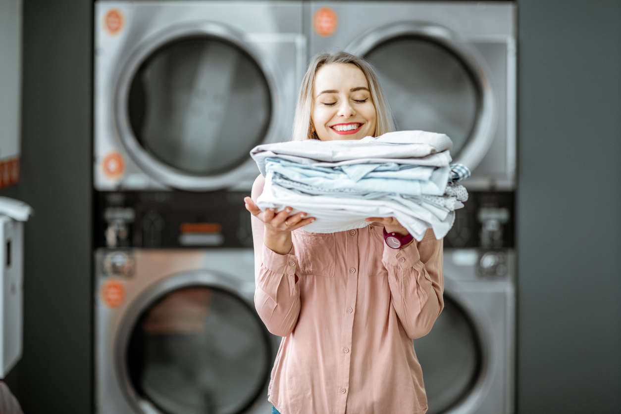 Woman holding pile of folded laundry